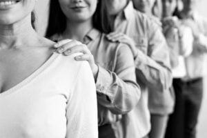 People touching each others shoulders in a line. Peer support.